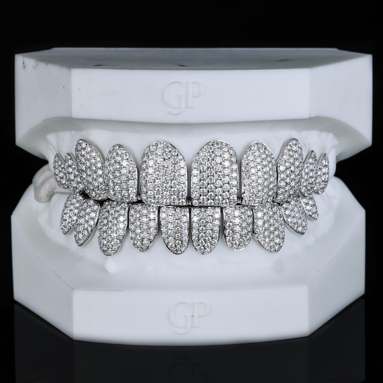 Full coverage moissanite grillz, top and bottom, on a white dental cast